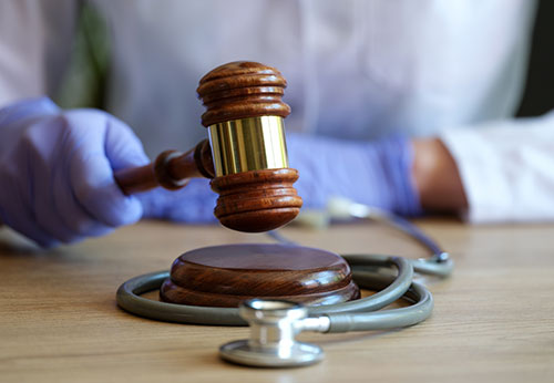 Judge's gavel and a stethoscope on a desk, representing different types of personal injury damages
