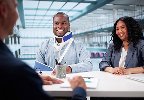Injured man in neck brace and sling consulting a professional; first steps after a Georgia accident.